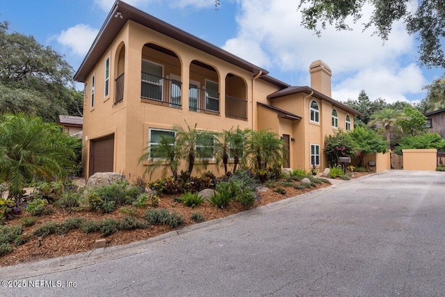 2348 Seminole Reach Ct, Atlantic Beach, FL 32233 - view of front of property featuring stucco siding, a chimney, a balcony, and an attached garage