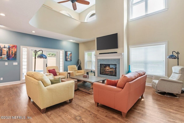 2348 Seminole Reach Ct, Atlantic Beach, FL 32233 - living area featuring a tiled fireplace, light wood-style flooring, a ceiling fan, recessed lighting, and a towering ceiling