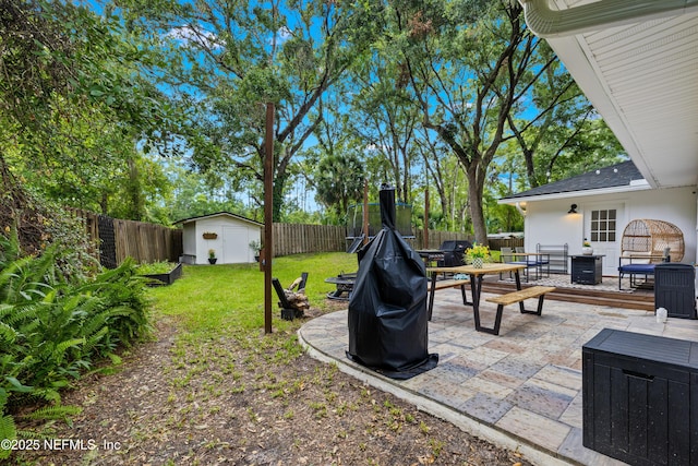 5263 Ellen Ct, Saint Augustine, FL 32086 - fenced backyard with outdoor dining space, a shed, a patio, and an outdoor fire pit
