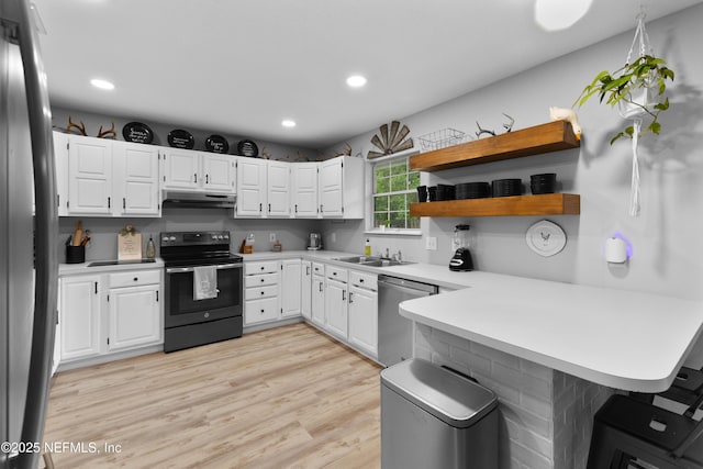 5263 Ellen Ct, Saint Augustine, FL 32086 - kitchen featuring appliances with stainless steel finishes, under cabinet range hood, a peninsula, light countertops, and recessed lighting
