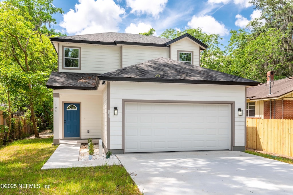 7708 Galveston Ave, Jacksonville, FL 32211 - view of front facade with an attached garage, a shingled roof, and concrete driveway