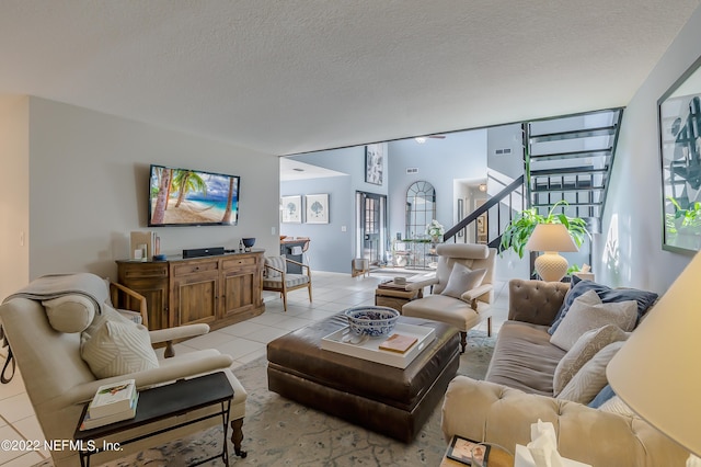 315 20th St, Atlantic Beach, FL 32233 - living room with stairway, light tile patterned floors, and a textured ceiling