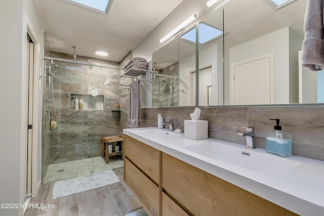 315 20th St, Atlantic Beach, FL 32233 - bathroom featuring a skylight, a marble finish shower, double vanity, and decorative backsplash