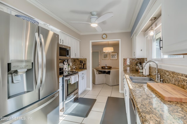 315 20th St, Atlantic Beach, FL 32233 - kitchen with stainless steel appliances, backsplash, white cabinetry, ceiling fan, and ornamental molding