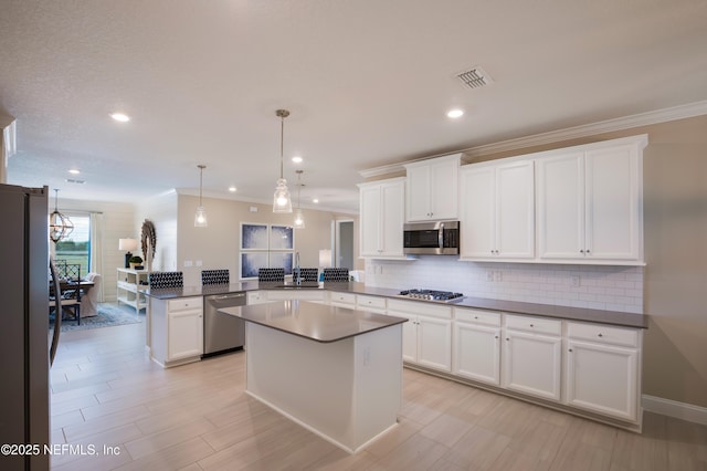 364 Higgins Loop, Saint Augustine, FL 32092 - kitchen with stainless steel appliances, a peninsula, backsplash, dark countertops, and ornamental molding