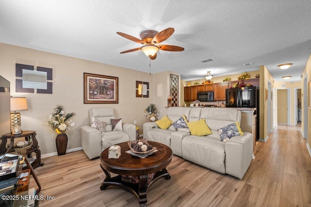 2548 Haywood Estates Ln, Jacksonville, FL 32233 - living room featuring ceiling fan, light wood-style floors, and a textured ceiling