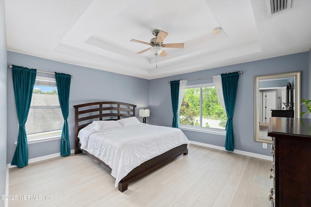 1563 Tawny Marsh Ct, Saint Augustine, FL 32092 - bedroom featuring a tray ceiling, light wood-style floors, and ceiling fan