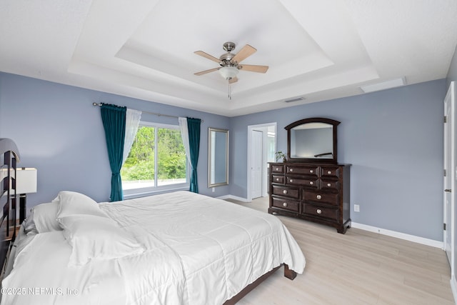 1563 Tawny Marsh Ct, Saint Augustine, FL 32092 - bedroom featuring a raised ceiling, light wood-type flooring, and a ceiling fan