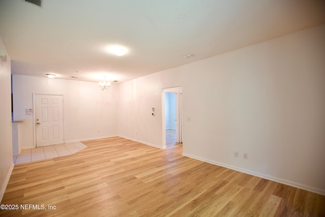 3600 Lenin Peak Ct Unit 8, Jacksonville, FL 32210 - empty room with light wood-type flooring and a chandelier