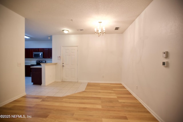 3600 Lenin Peak Ct Unit 8, Jacksonville, FL 32210 - unfurnished dining area featuring a chandelier, light wood finished floors, and a textured ceiling
