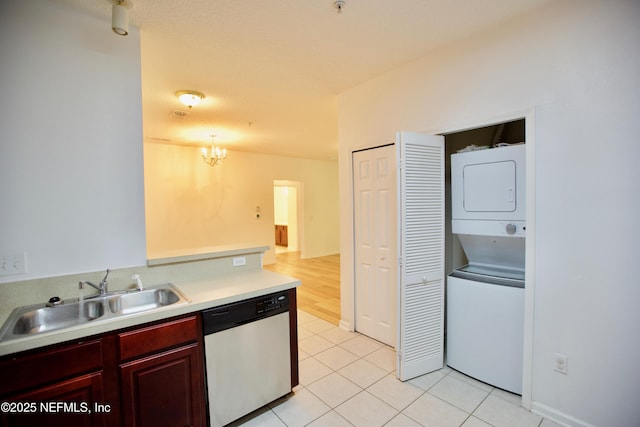 3600 Lenin Peak Ct Unit 8, Jacksonville, FL 32210 - kitchen with stainless steel dishwasher, stacked washer / drying machine, reddish brown cabinets, light countertops, and a chandelier