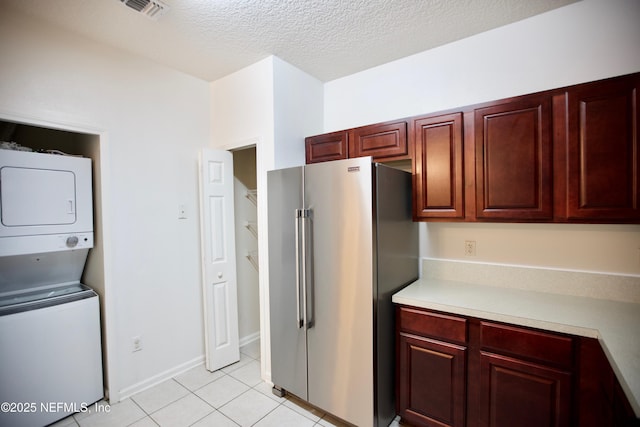 3600 Lenin Peak Ct Unit 8, Jacksonville, FL 32210 - kitchen featuring high quality fridge, stacked washing machine and dryer, light countertops, light tile patterned flooring, and reddish brown cabinets