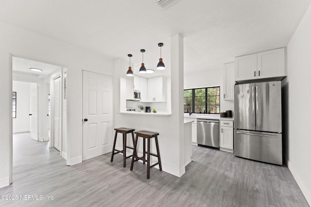 6285 Spring Forest Cir, Jacksonville, FL 32216 - kitchen with appliances with stainless steel finishes, light wood finished floors, and white cabinets