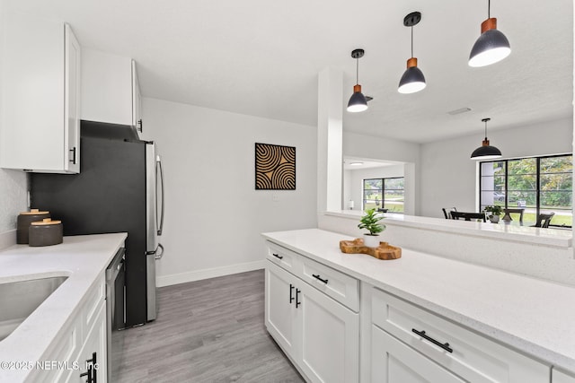 6285 Spring Forest Cir, Jacksonville, FL 32216 - kitchen featuring white cabinetry, light wood-style flooring, hanging light fixtures, stainless steel dishwasher, and light stone countertops
