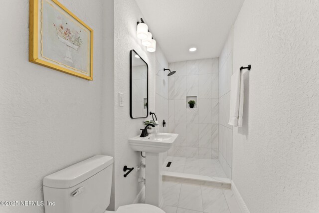 6285 Spring Forest Cir, Jacksonville, FL 32216 - bathroom with a tile shower, marble finish floors, and a textured wall