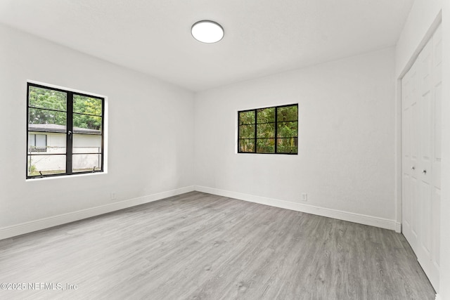 6285 Spring Forest Cir, Jacksonville, FL 32216 - unfurnished bedroom with multiple windows, wood finished floors, and a closet