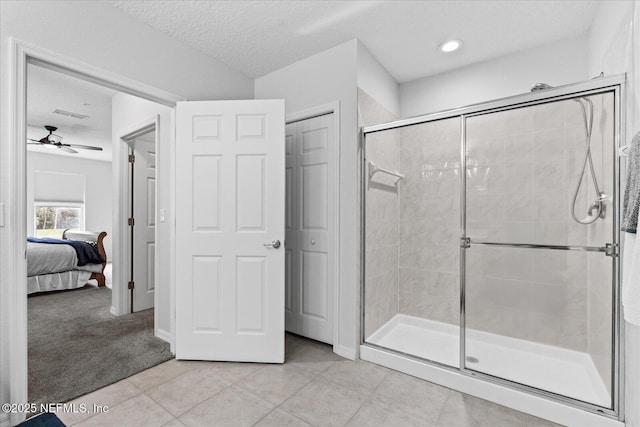 1200 Canopy Walk Ln Unit 1212, Palm Coast, FL 32137 - ensuite bathroom with a shower stall, a ceiling fan, tile patterned flooring, and a textured ceiling