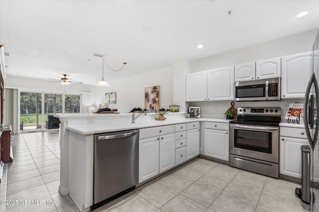1200 Canopy Walk Ln Unit 1212, Palm Coast, FL 32137 - kitchen with stainless steel appliances, a peninsula, open floor plan, white cabinetry, and light tile patterned floors