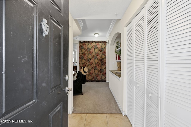 10435 Mid Town Pkwy Unit 265, Jacksonville, FL 32246 - hallway with crown molding, light colored carpet, light tile patterned floors, arched walkways, and wallpapered walls