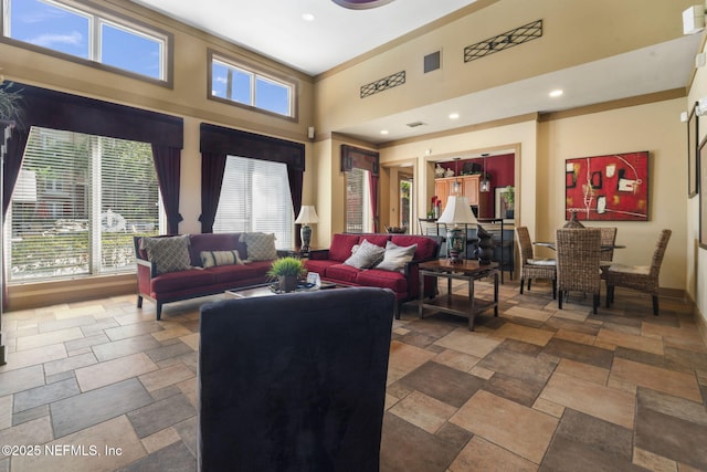 10435 Mid Town Pkwy Unit 265, Jacksonville, FL 32246 - living area featuring stone tile floors, a towering ceiling, recessed lighting, and crown molding