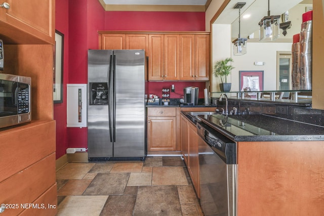 10435 Mid Town Pkwy Unit 265, Jacksonville, FL 32246 - kitchen featuring appliances with stainless steel finishes, stone finish floors, brown cabinetry, dark stone counters, and a peninsula