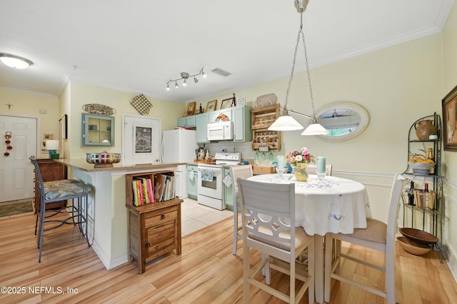 130 Old Town Pkwy Unit 2202, Saint Augustine, FL 32084 - kitchen with white appliances, crown molding, a breakfast bar, light wood-style flooring, and a peninsula