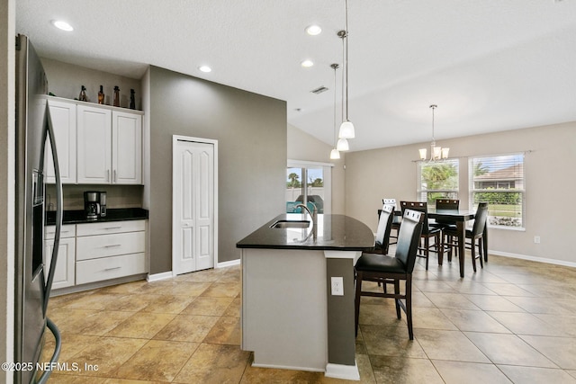 222 Green Turtle Ln, Saint Augustine, FL 32086 - kitchen featuring dark countertops, stainless steel fridge with ice dispenser, vaulted ceiling, a kitchen bar, and plenty of natural light
