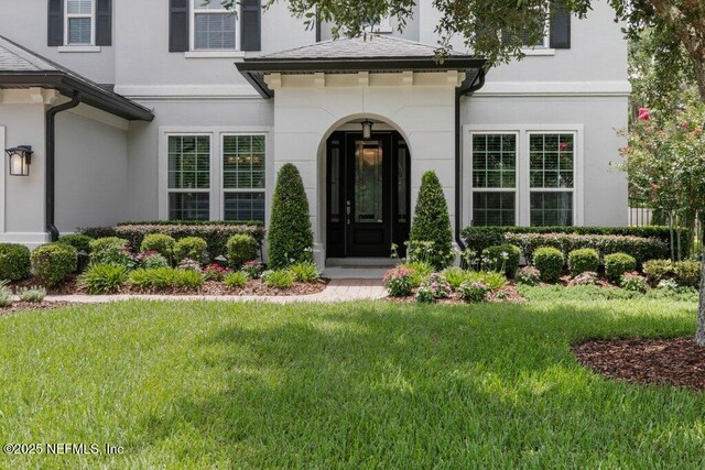 26 Traveler Palm Ct, Ponte Vedra Beach, FL 32082 - doorway to property featuring stucco siding and a lawn