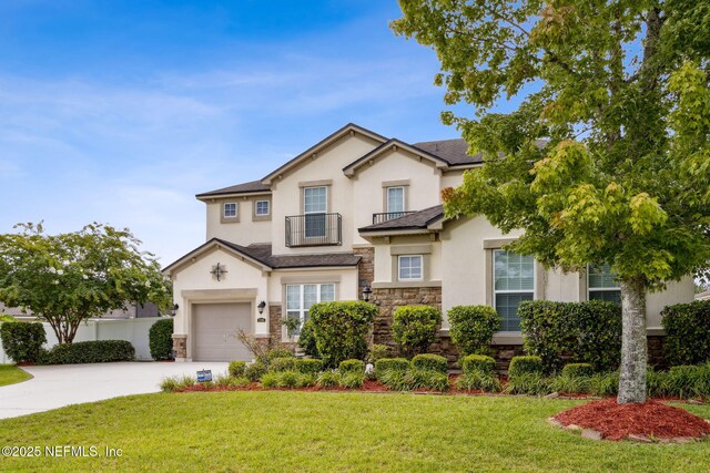 1306 Warbler Way, Middleburg, FL 32068 - traditional-style house with stucco siding, a balcony, stone siding, concrete driveway, and a front yard