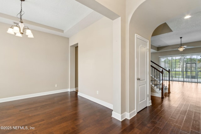 1306 Warbler Way, Middleburg, FL 32068 - unfurnished room with arched walkways, a ceiling fan, a chandelier, dark wood-style flooring, and stairway