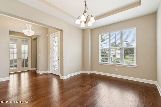 1306 Warbler Way, Middleburg, FL 32068 - empty room with a chandelier, french doors, dark wood finished floors, and a tray ceiling