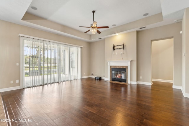 1306 Warbler Way, Middleburg, FL 32068 - unfurnished living room featuring a tray ceiling, a ceiling fan, hardwood / wood-style floors, and a fireplace