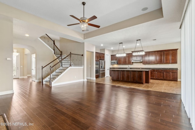 1306 Warbler Way, Middleburg, FL 32068 - unfurnished living room featuring a ceiling fan, arched walkways, wood-type flooring, stairway, and recessed lighting