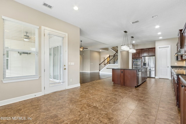 1306 Warbler Way, Middleburg, FL 32068 - kitchen featuring stainless steel refrigerator with ice dispenser, open floor plan, a kitchen island with sink, a ceiling fan, and hanging light fixtures