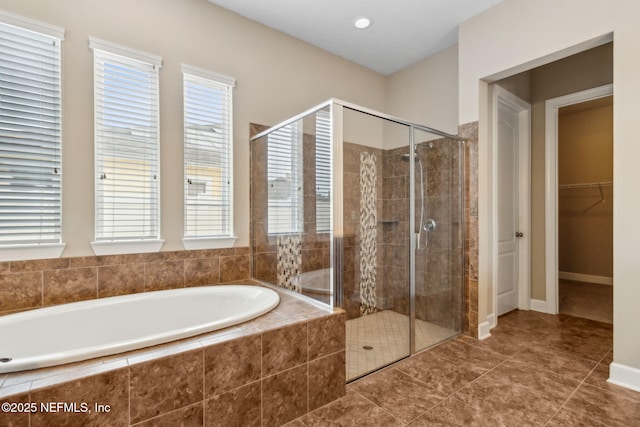 1306 Warbler Way, Middleburg, FL 32068 - bathroom with a garden tub, a shower stall, a walk in closet, and tile patterned flooring