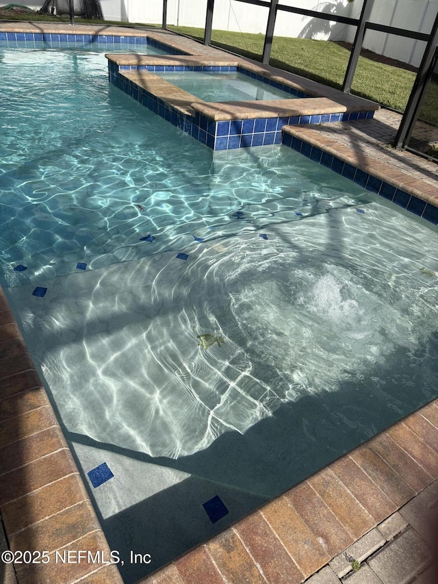 1306 Warbler Way, Middleburg, FL 32068 - view of swimming pool featuring a pool with connected hot tub and glass enclosure