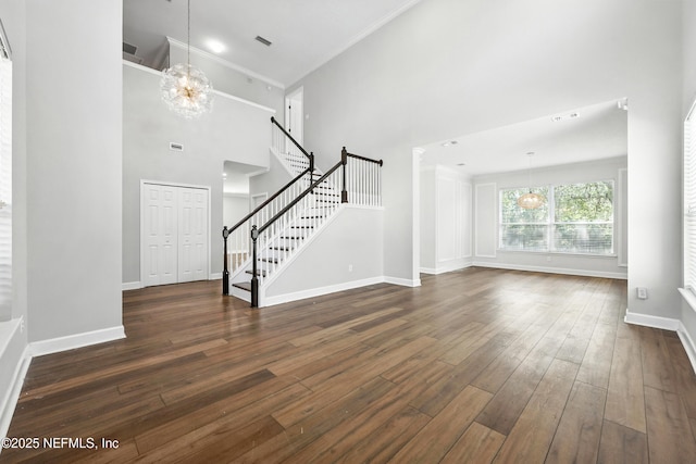 12490 Tropic Dr, Jacksonville, FL 32225 - unfurnished living room featuring a chandelier, a towering ceiling, stairs, dark wood finished floors, and ornamental molding