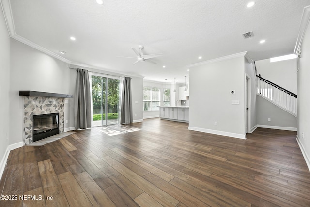 12490 Tropic Dr, Jacksonville, FL 32225 - unfurnished living room with a ceiling fan, crown molding, stairway, a fireplace, and dark wood finished floors