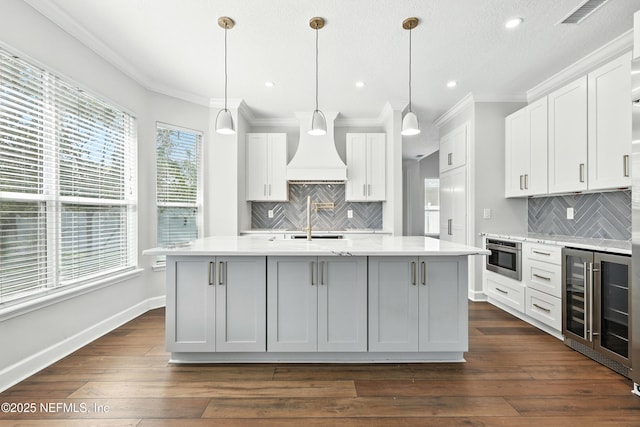 12490 Tropic Dr, Jacksonville, FL 32225 - kitchen featuring wine cooler, crown molding, backsplash, custom exhaust hood, and white cabinets