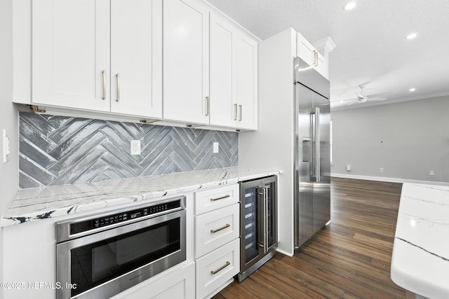 12490 Tropic Dr, Jacksonville, FL 32225 - kitchen featuring built in appliances, wine cooler, ceiling fan, light stone countertops, and recessed lighting