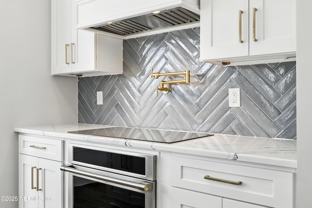 12490 Tropic Dr, Jacksonville, FL 32225 - kitchen featuring stainless steel oven, premium range hood, white cabinets, and tasteful backsplash