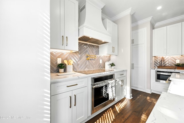 12490 Tropic Dr, Jacksonville, FL 32225 - kitchen featuring stainless steel oven, premium range hood, black electric stovetop, backsplash, and crown molding