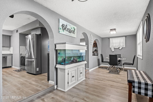 5414 Cleveland Rd, Jacksonville, FL 32209 - office space featuring a textured ceiling, light wood-style flooring, a textured wall, and arched walkways