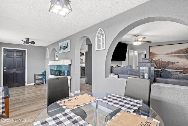 5414 Cleveland Rd, Jacksonville, FL 32209 - dining space featuring a ceiling fan, arched walkways, a textured ceiling, and light wood-type flooring