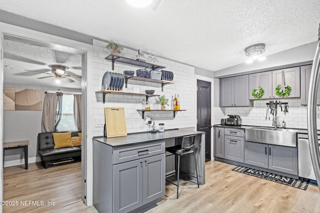5414 Cleveland Rd, Jacksonville, FL 32209 - kitchen with gray cabinetry, a textured ceiling, dark countertops, open shelves, and decorative backsplash