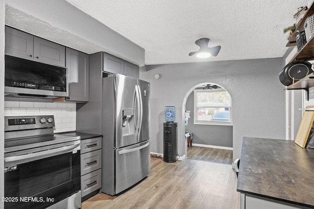 5414 Cleveland Rd, Jacksonville, FL 32209 - kitchen with stainless steel appliances, dark countertops, backsplash, light wood-type flooring, and a textured ceiling