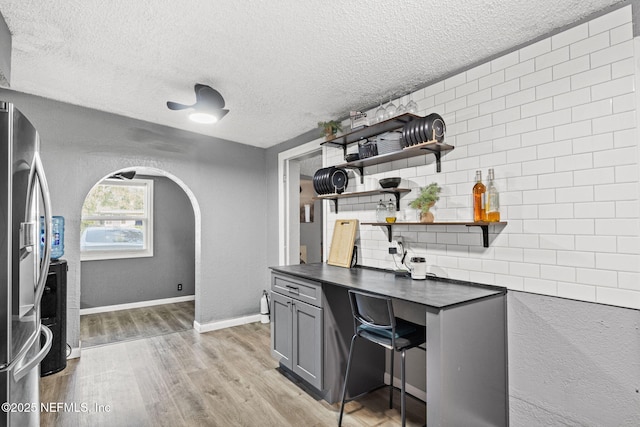 5414 Cleveland Rd, Jacksonville, FL 32209 - home office with a textured ceiling, arched walkways, and light wood-style flooring
