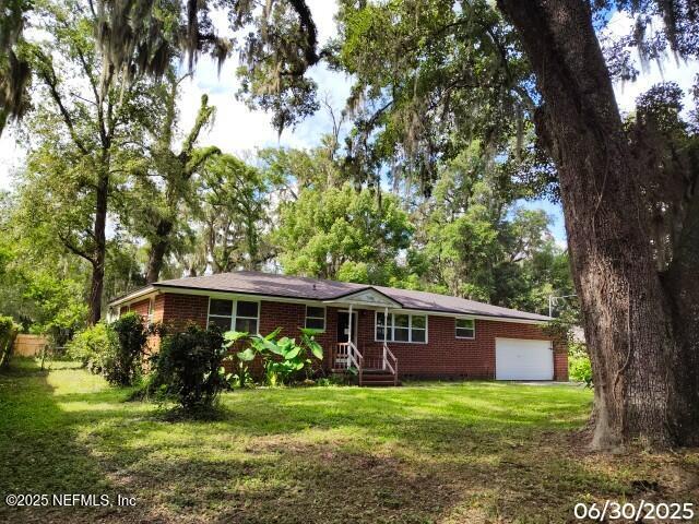 7228 Zona Ave, Jacksonville, FL 32211 - single story home with brick siding, a front lawn, and an attached garage