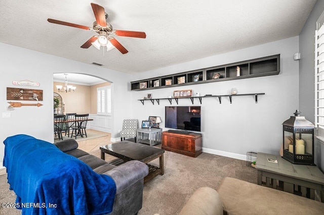 11598 Wynnfield Lakes Cir, Jacksonville, FL 32246 - living room with arched walkways, a ceiling fan, a chandelier, a textured ceiling, and carpet floors
