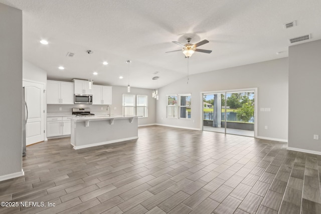 83687 Nether St, Fernandina Beach, FL 32034 - unfurnished living room featuring lofted ceiling, a ceiling fan, wood finished floors, recessed lighting, and a textured ceiling